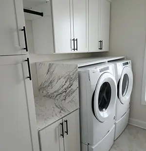 Laundry cabinets in White, Mission doors, ThinScape waterfall countertop, crown molding.