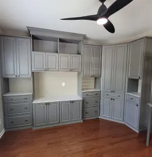 Closet system in Folkstone Grey; Mission doors, panel lighting, and glass-inset top for the island; Black backing; crown, base, and fluted moldings