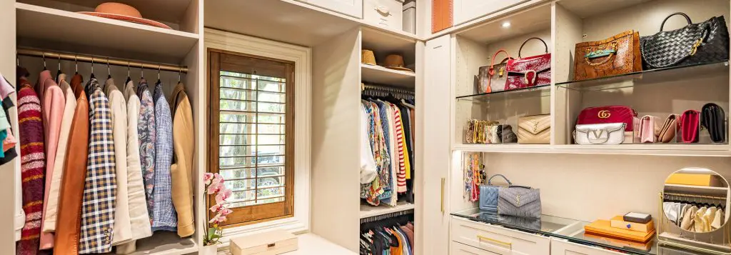 Walk in closet with custom purse display shelving by Closet Factory Dallas