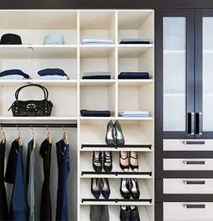 Custom closet with sleek shelving and shoe storage, featuring pull-out racks, cubbies for accessories