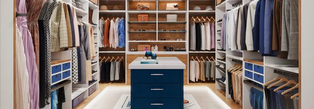 Modern walk-in closet with a central navy island, white shelving, warm wood accents, and under-cabinet lighting, featuring neatly organized clothing, shoes