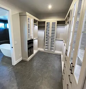 Spacious walk-in closet with glass-front cabinetry