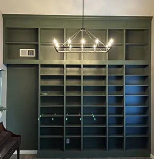 Custom wall-unit with built-in shelving in dark green
