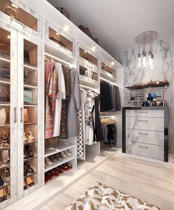 Modern custom closet with white marble finishes, glass-front cabinets, LED lighting
