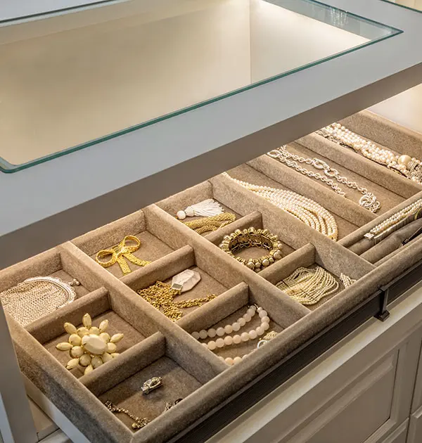 Tan velvet jewelry tray on pull-out shelf, counter with glass cutout