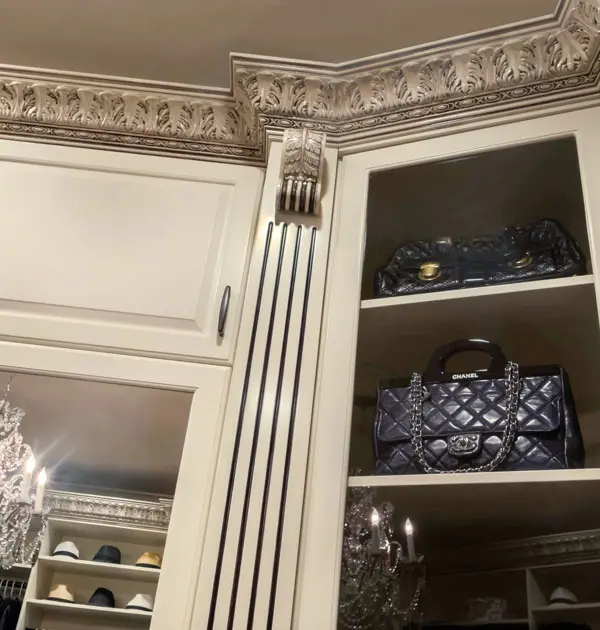 Upper cabinet detail with decorative molding and open display shelving.