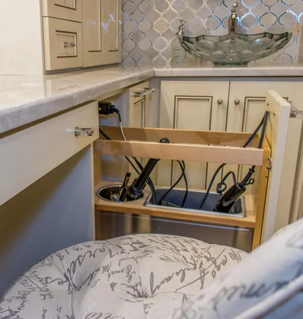 Pull-out cabinet drawer with built-in power outlets and cord storage.