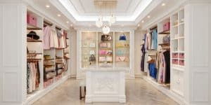 A walk-in closet with an island, recessed lighting, and chandelier
