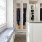 LArge walk in closet in white with a window seat