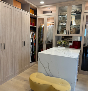 custom closet in light brown with a white island in marbel