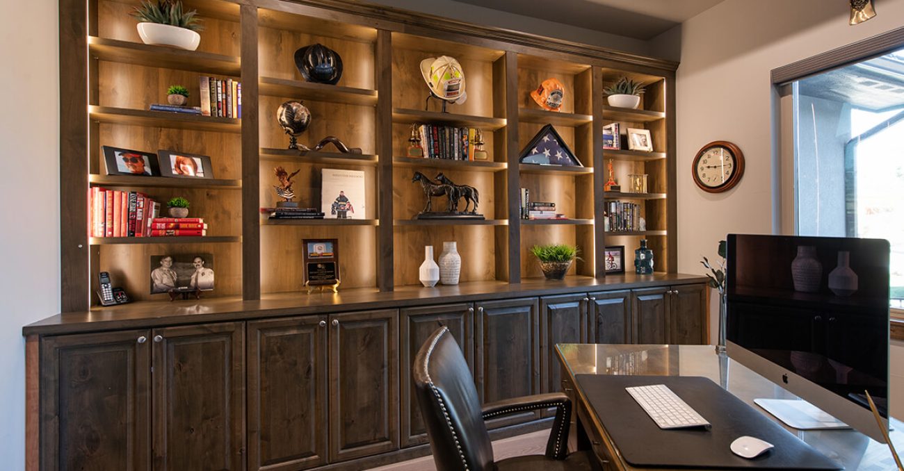 Book case shelving in office with LED lighting and custom cabinetry in dark wood tone