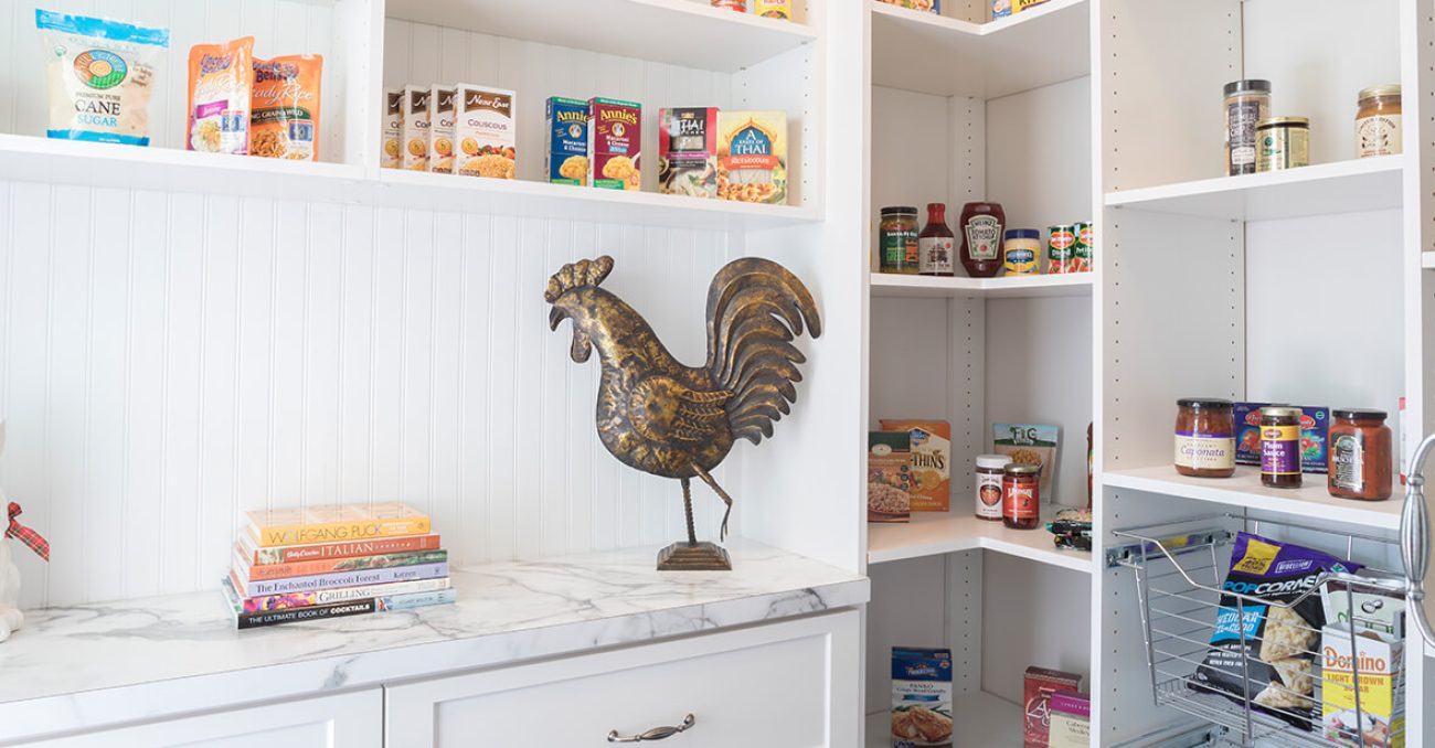 Charming pantry with white beadboard walls and marble counters