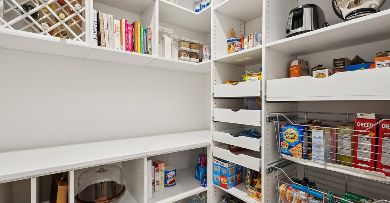 White walk-in pantry featuring pull-out drawers, vertical wine storage, and open shelving for dry goods and small appliances.
