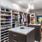 Luxury walk-in closet with dual islands, expansive shoe shelving, and custom wardrobe sections