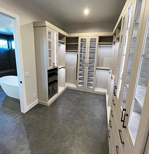 Spacious walk-in closet with glass-front cabinetry