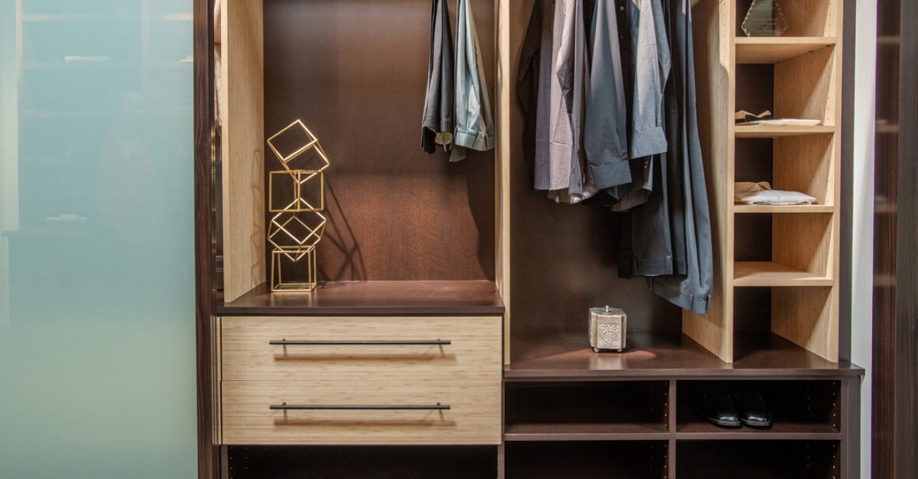 Reach-in closet in Summer Breeze with Cocoa backing. Includes open shelving, cubbies for folded clothing, and drawers with long matte black bar pulls.