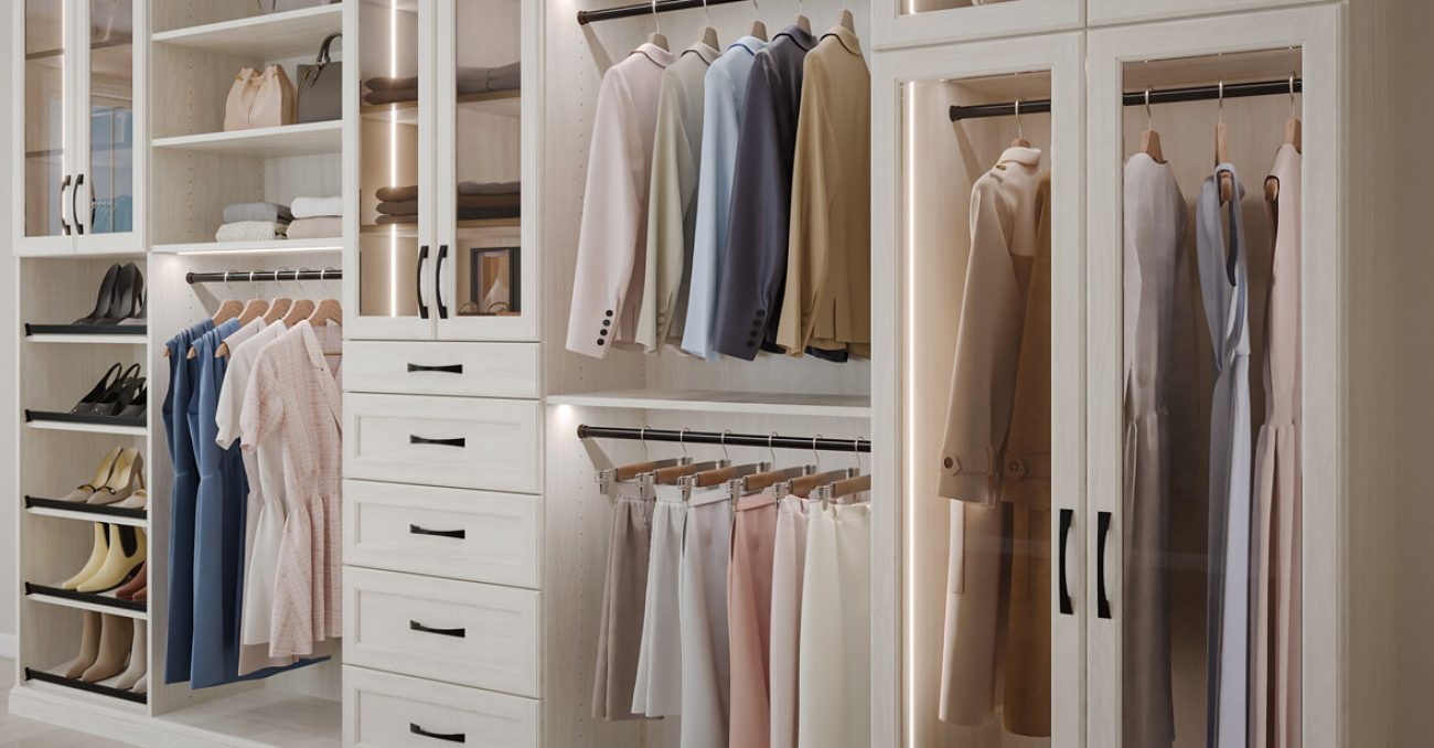 Reach-in closet with elegant white wood cabinetry, LED lighting, and pull-out shoe storage and double hanging garment rods.