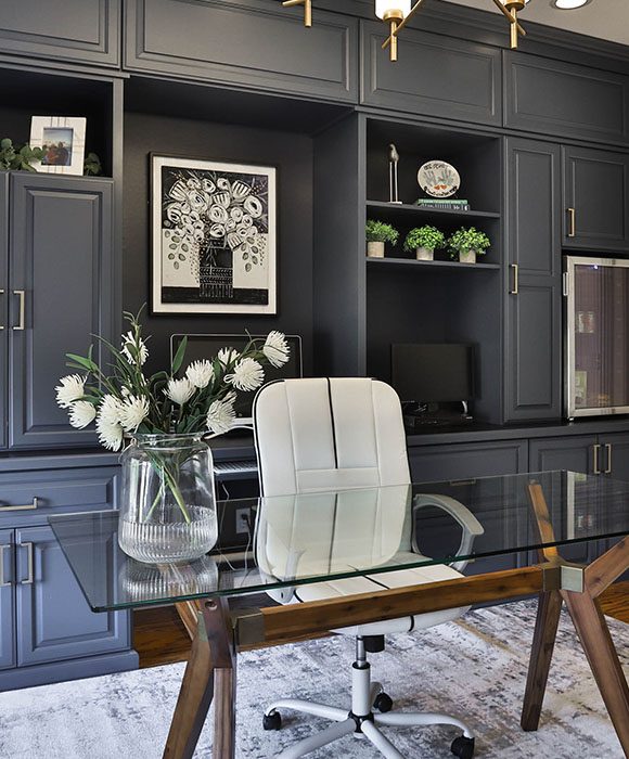 Custom home office system with upper and lower cabinetry, glass display doors, and crown molding.