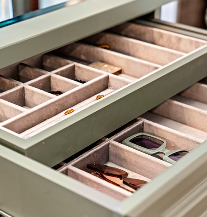 Soft-lined drawer organizer in a sage green finish holding sunglasses and accessories