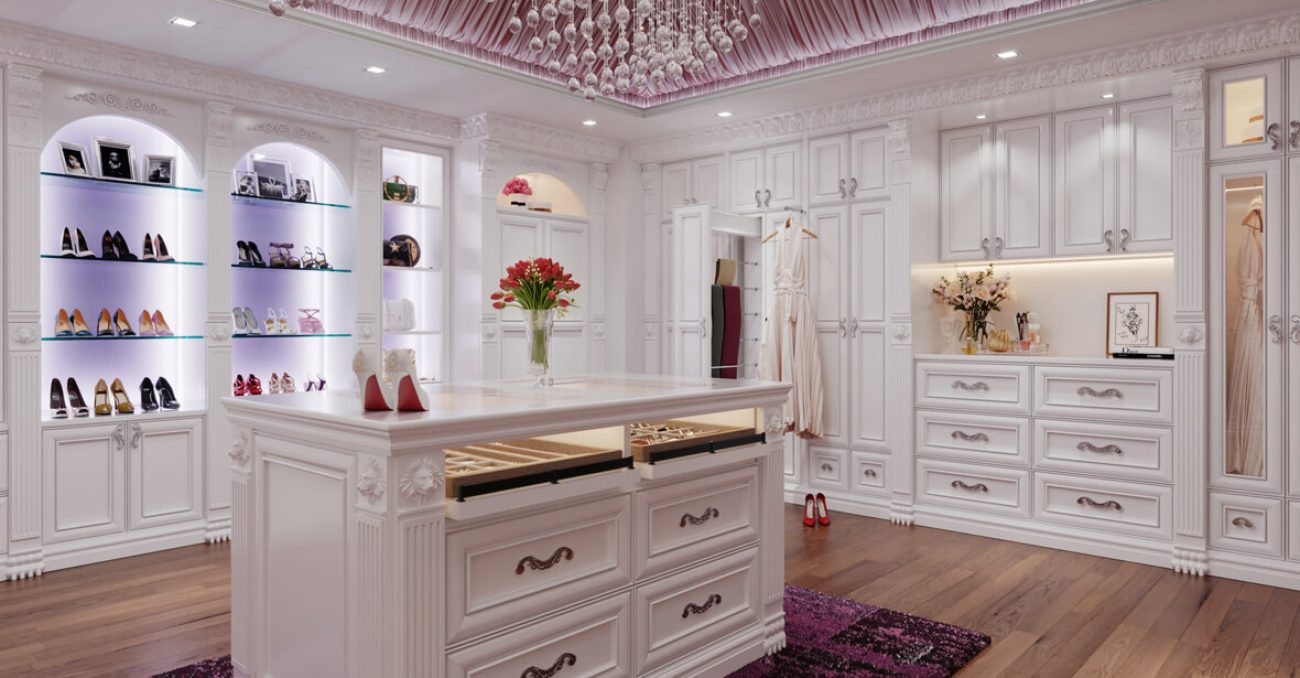Custom walk-in closet with wall-to-wall cabinetry, open shoe shelving with LED lighting, and custom island with pull-out jewelry and accessory drawers