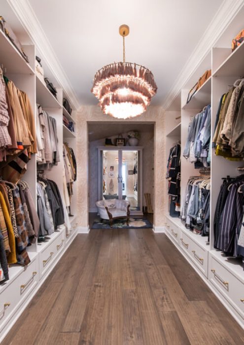 Elegant white closet with symmetrical shelving, brass drawer handles