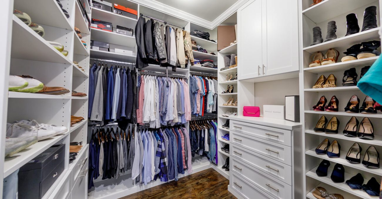 Custom walk-in closet with white soft-close drawers and cabinetry, open shoe shelves, and organizers