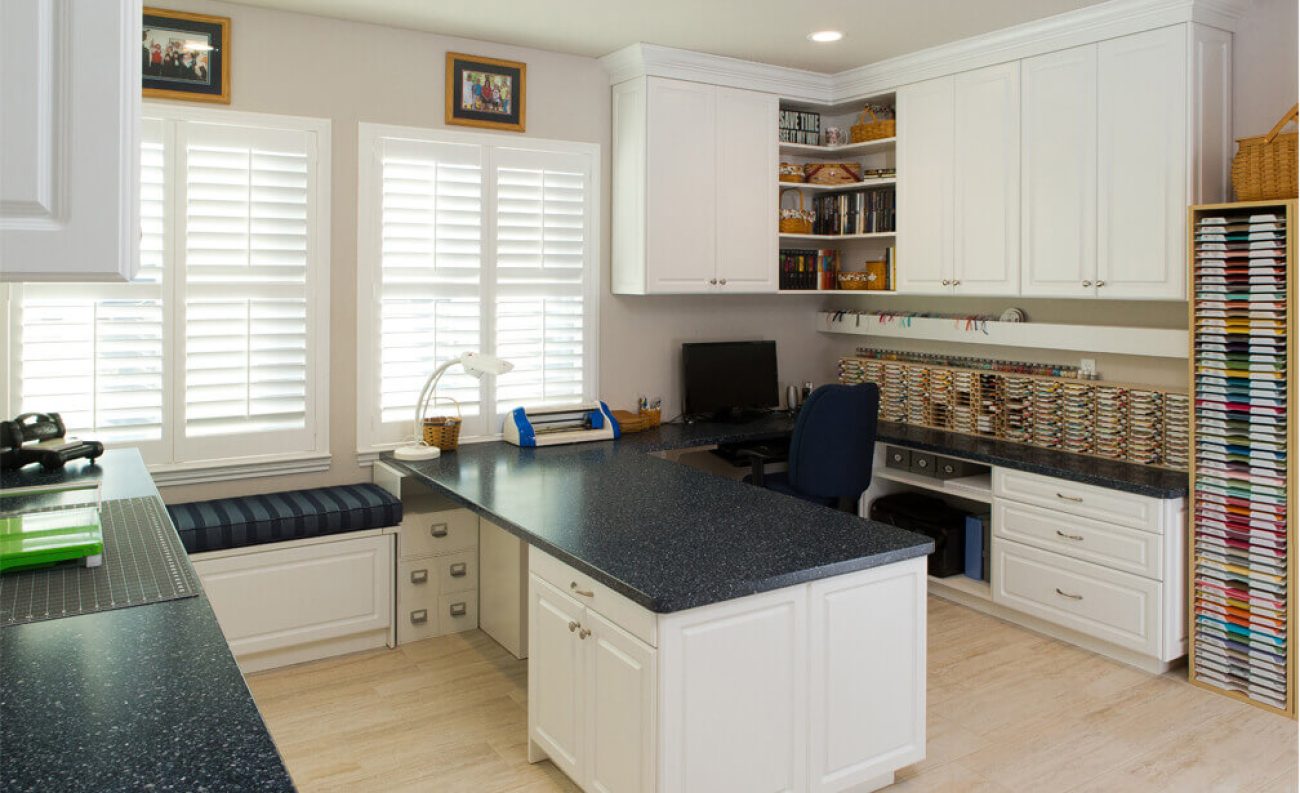 Craft room Thread storage wall, ribbon rods, and media shelving built into White Chocolate Raised Panel cabinetry
