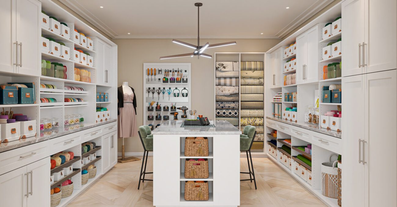 Craft room Shaker cabinets with craft room accessories including ribbon dispensers, fabric pull-outs, and a tool wall. Center island features open basket storage.