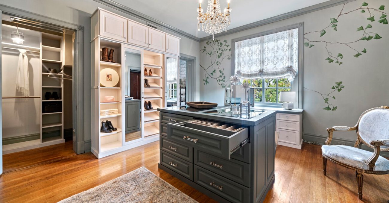 Dressing room featuring central island with velvet jewelry drawers, LED lighting, elite toe stops, and white shaker cabinetry