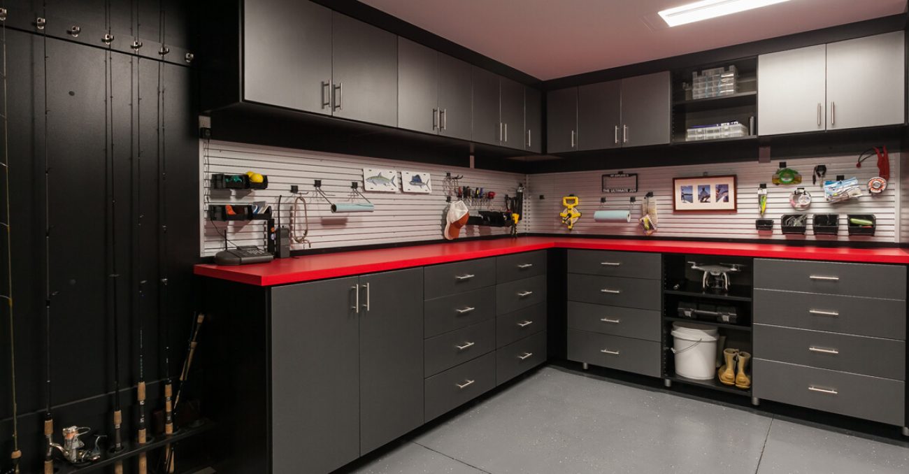 Custom garage cabinetry with slatwall organizers, fishing racks, and utility hooks