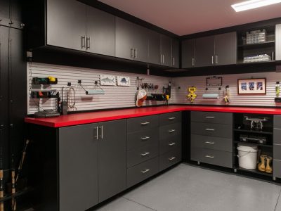 Custom garage cabinetry with slatwall organizers, fishing racks, and utility hooks
