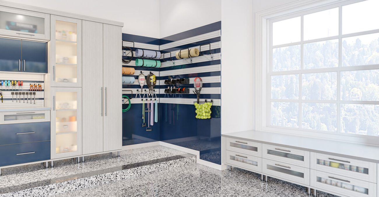 Garage setup with mounted sports gear organizers, cabinetry with lighting, and a wraparound bench
