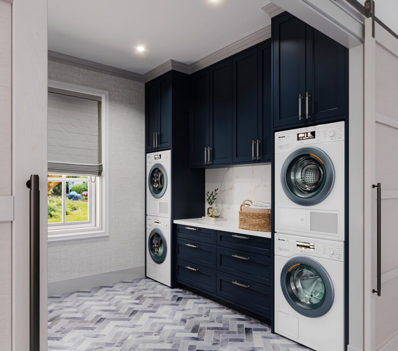 Laundry room with dual washer and dryer with folding station and dark blue upper cabinetry