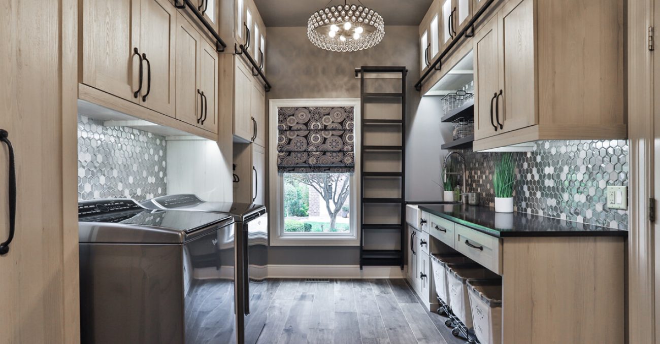 Custom laundry room with ladder for high reach items and fabric rolling laundry bins