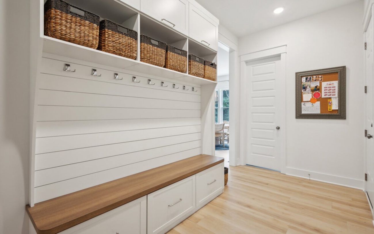 Custom entryway mudroom with coat hooks. shiplap, and built-in bench
