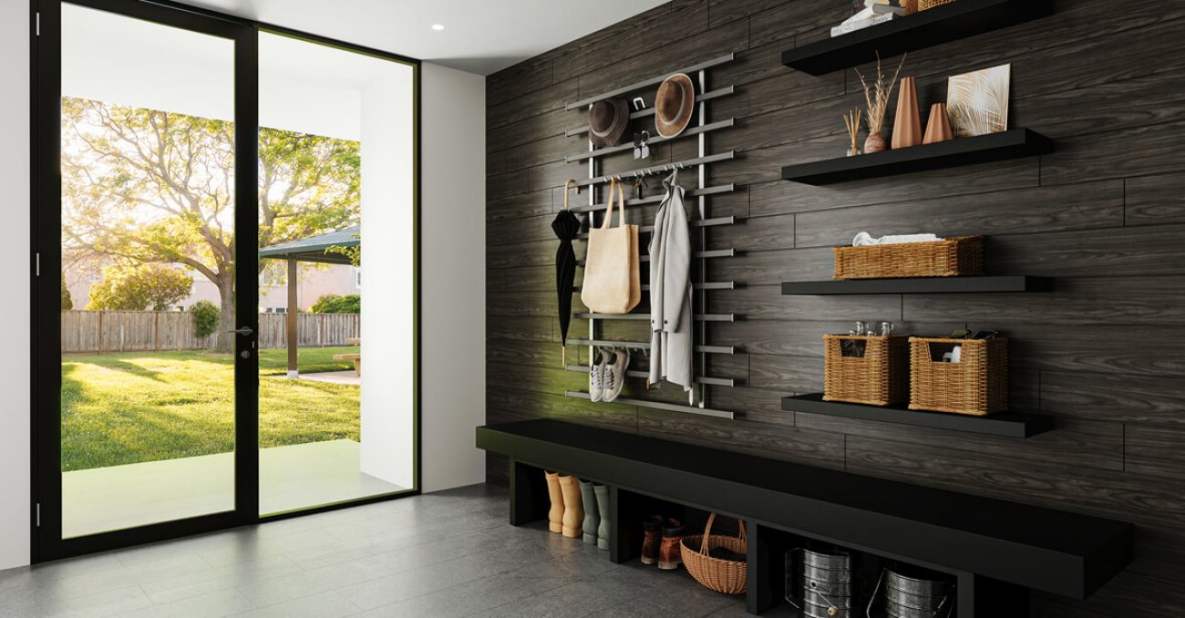 Modern mudroom with a black bench, black wood-paneled wall, and minimalist metal peg system for coats and hats