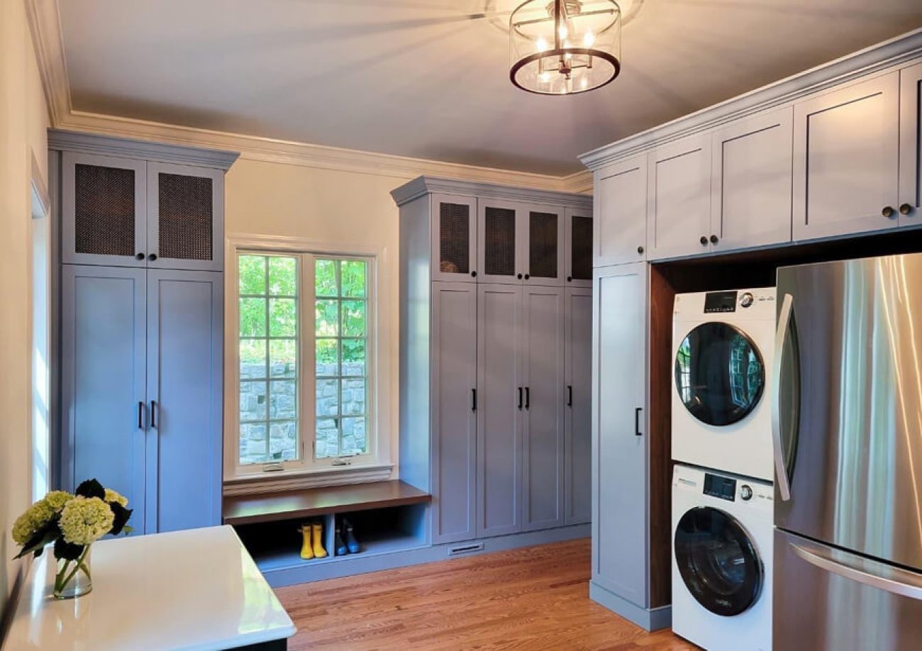 Stylish gray mudroom with tall cabinets, built-in bench seating