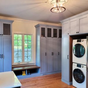Stylish gray mudroom with tall cabinets, built-in bench seating