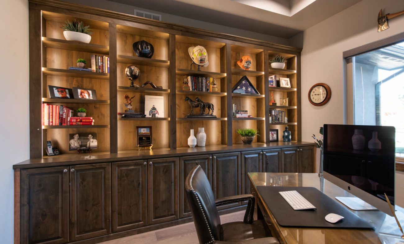 Custom wood wall unit with built-in lighting, open display shelving, and lower closed cabinetry