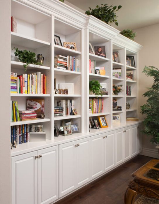White built-in wall unit with open shelving and lower cabinets with crown molding