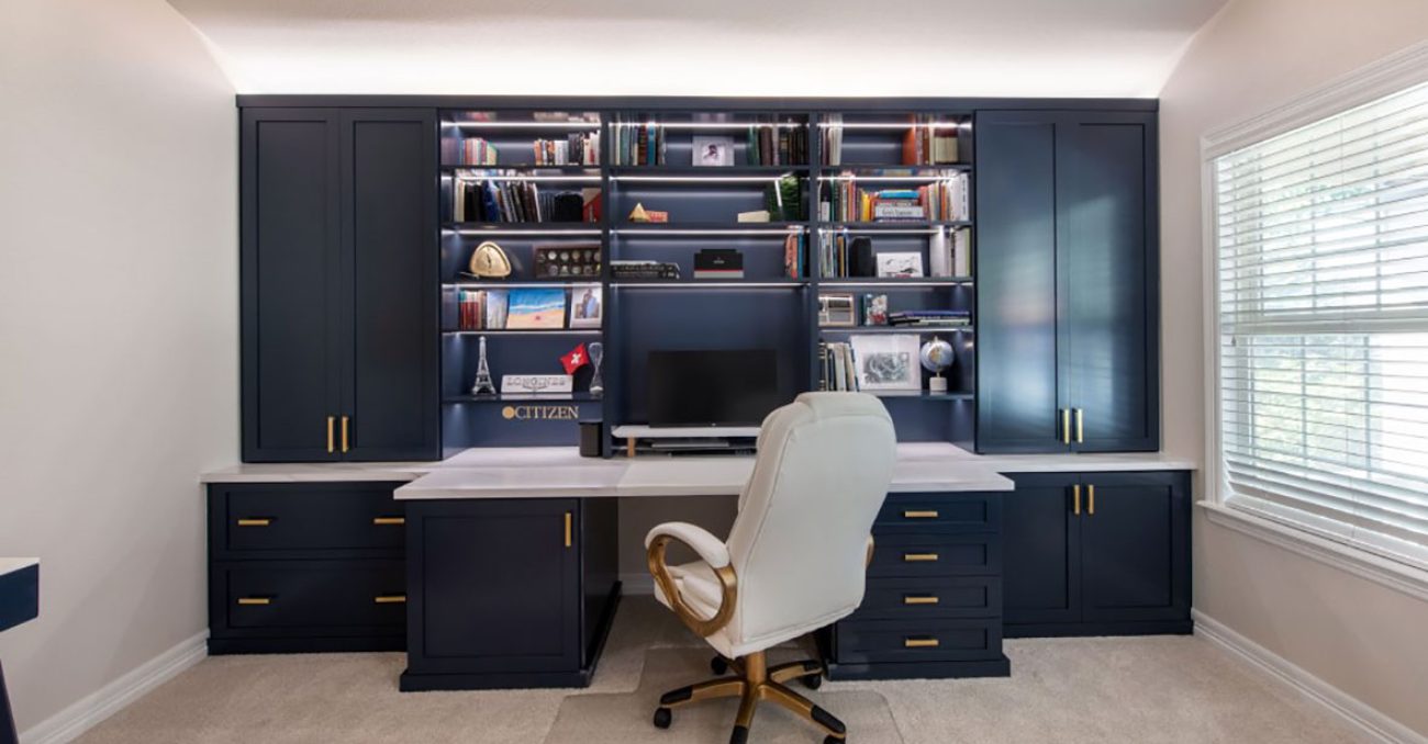 Built-in desk with side full height cabinets and open book shelving with LED light strips.