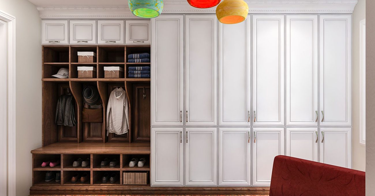 Mudroom wall unit with full height concealed storage cabinets, built-in bench, coat hooks, and shoe shelving.
