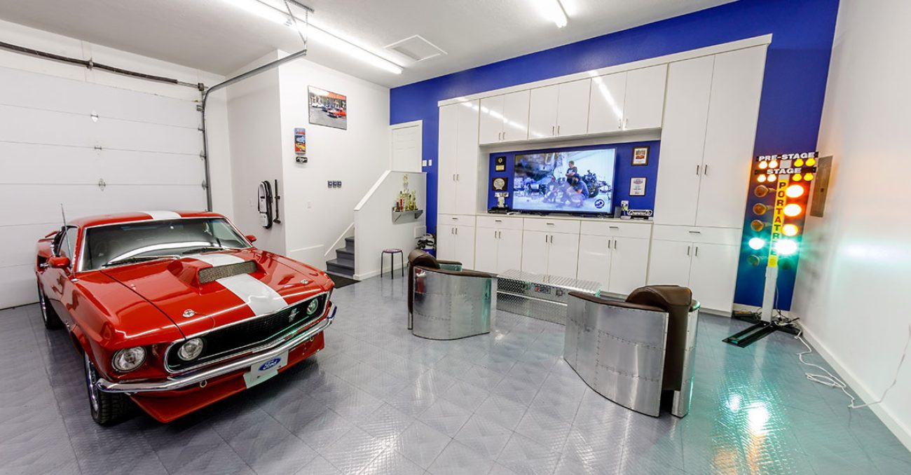 High-gloss white garage storage cabinetry with integrated TV mount.