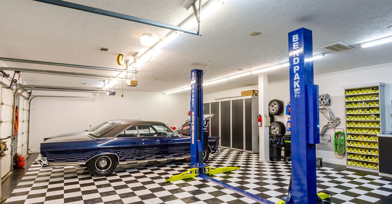 Stylized garage system with black melamine cabinetry, open shelving, and slatwall organizer.