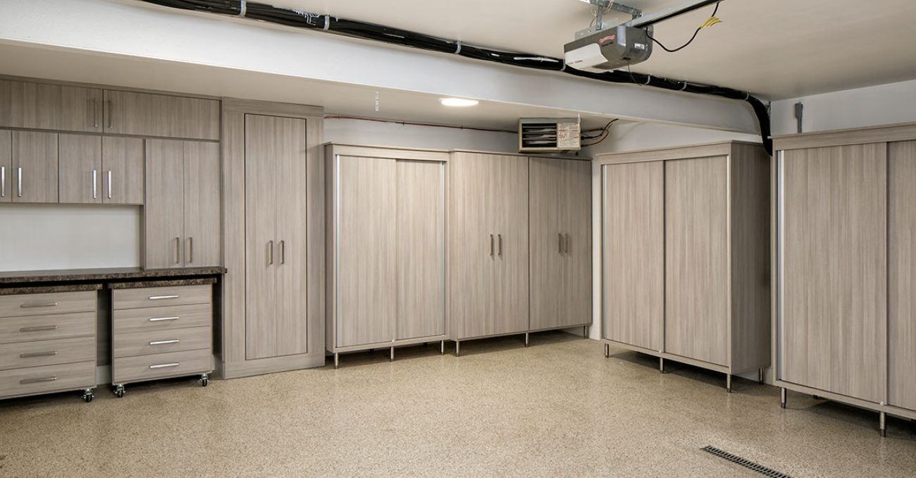 Garage cabinetry with sliding doors and workstation drawers on wheels for easy mobility.