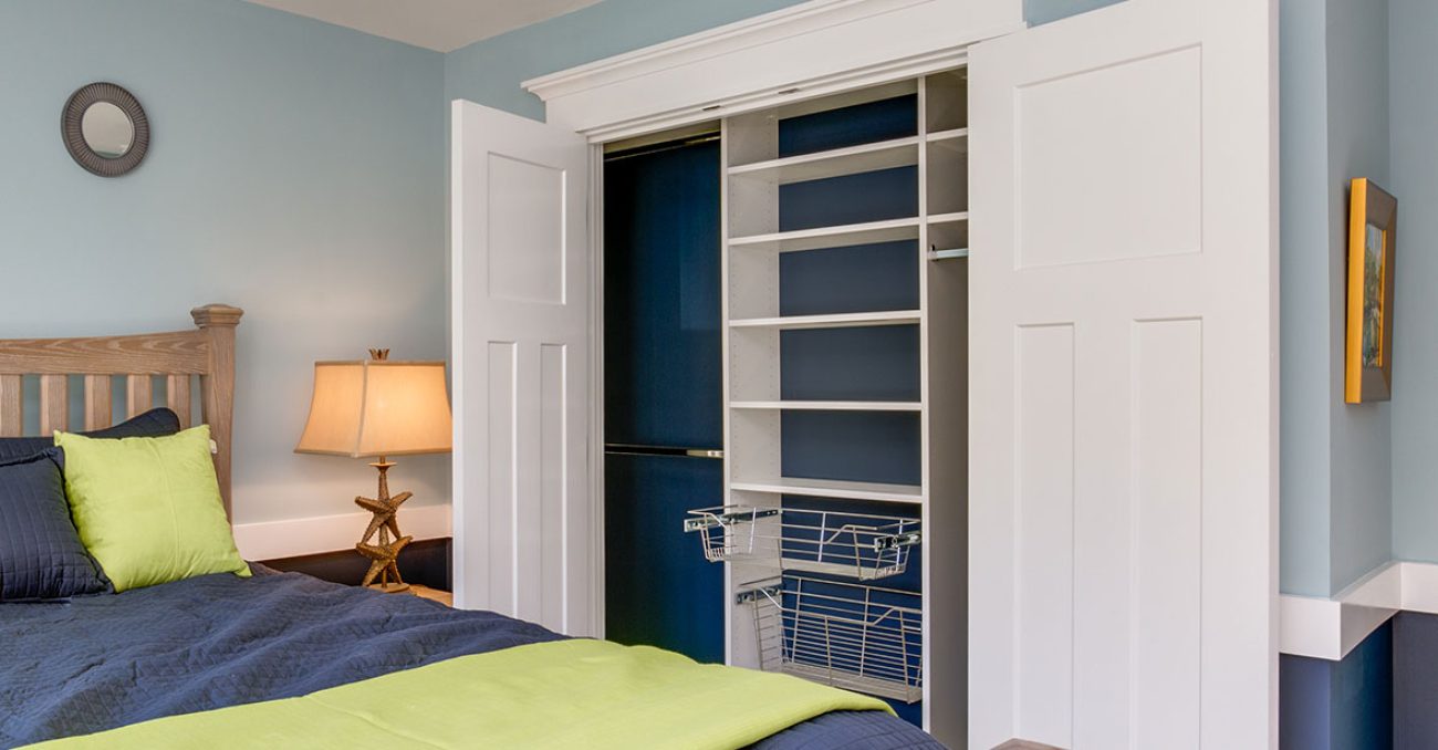 Reach-in closet with pull out wire baskets and dual hanging rods.